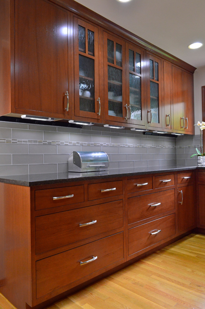 Large transitional l-shaped medium tone wood floor and brown floor open concept kitchen photo in Seattle with an undermount sink, flat-panel cabinets, dark wood cabinets, quartz countertops, gray backsplash, subway tile backsplash, stainless steel appliances and an island