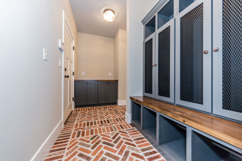 Mudroom - mid-sized transitional brick floor and red floor mudroom idea in St Louis with beige walls