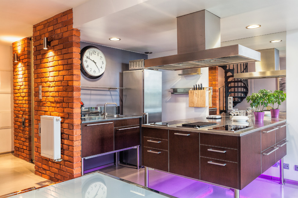 Mid-sized urban single-wall eat-in kitchen photo with an undermount sink, flat-panel cabinets, brown cabinets, stainless steel countertops, stainless steel appliances and an island