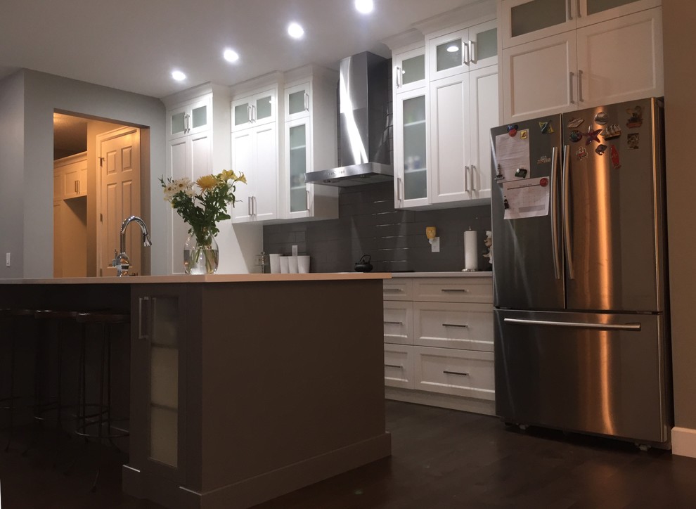 Mid-sized single-wall dark wood floor eat-in kitchen photo in Calgary with an undermount sink, shaker cabinets, white cabinets, quartzite countertops, gray backsplash, subway tile backsplash, stainless steel appliances and an island