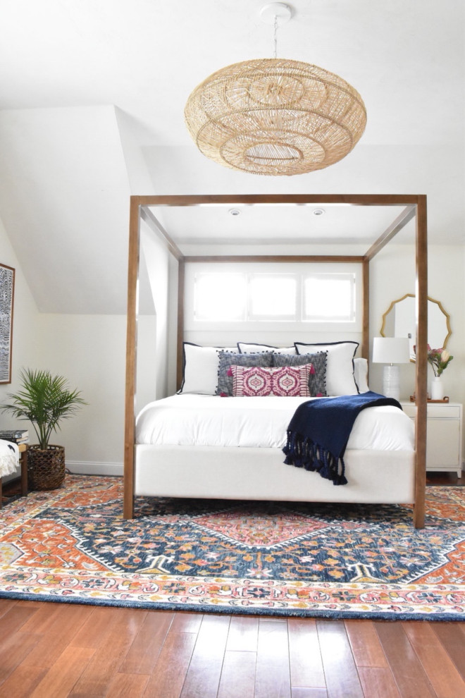 This is an example of a mid-sized eclectic master bedroom in Boston with white walls, medium hardwood floors and brown floor.
