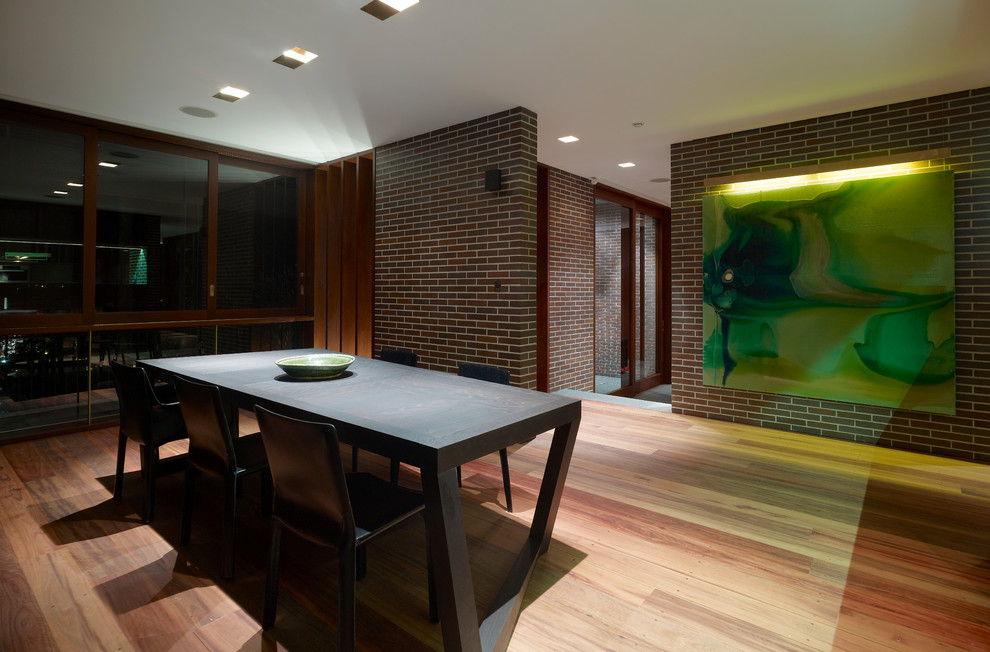 Photo of a modern dining room in Sydney with light hardwood floors.