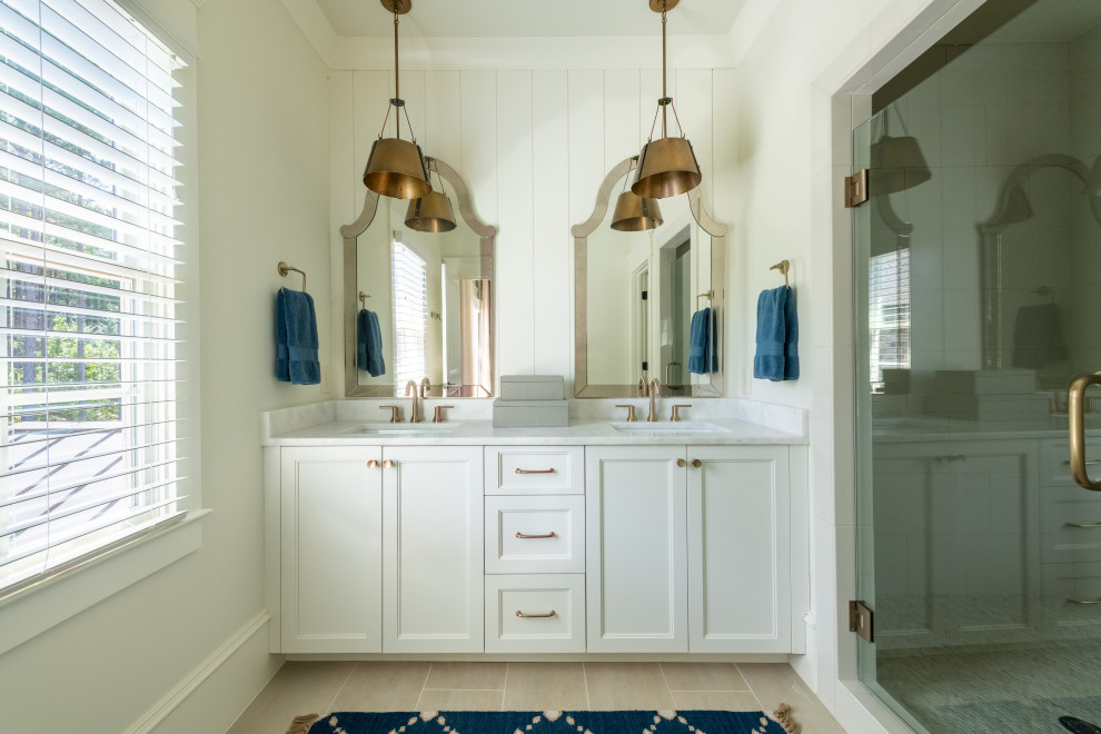 Inspiration for a large transitional kids bathroom in Atlanta with recessed-panel cabinets, white cabinets, a freestanding tub, an alcove shower, ceramic floors, marble benchtops, beige floor, a hinged shower door, white benchtops, a shower seat, a double vanity, a built-in vanity, white walls and planked wall panelling.