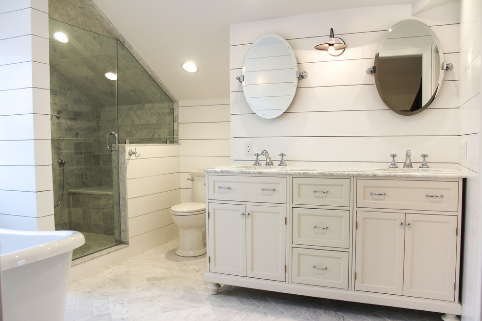 Inspiration for a large arts and crafts master bathroom in New York with furniture-like cabinets, white cabinets, a freestanding tub, an alcove shower, a one-piece toilet, white tile, ceramic tile, white walls, ceramic floors, a drop-in sink and marble benchtops.