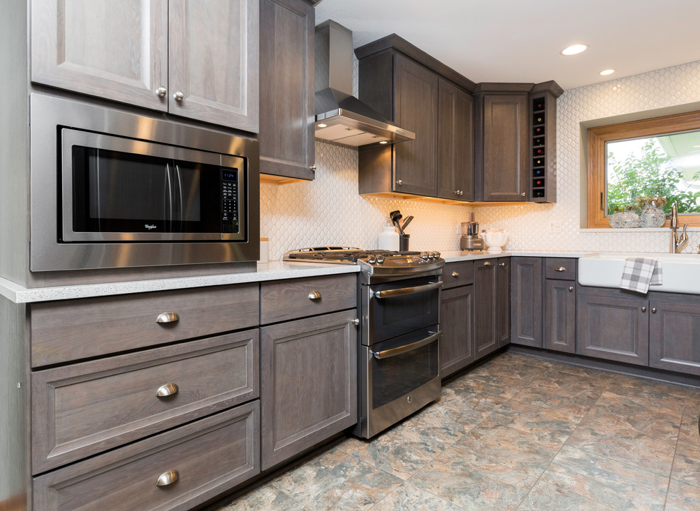 Eat-in kitchen - mid-sized transitional l-shaped vinyl floor and gray floor eat-in kitchen idea with a farmhouse sink, recessed-panel cabinets, gray cabinets, quartz countertops, white backsplash, ceramic backsplash, stainless steel appliances, no island and white countertops