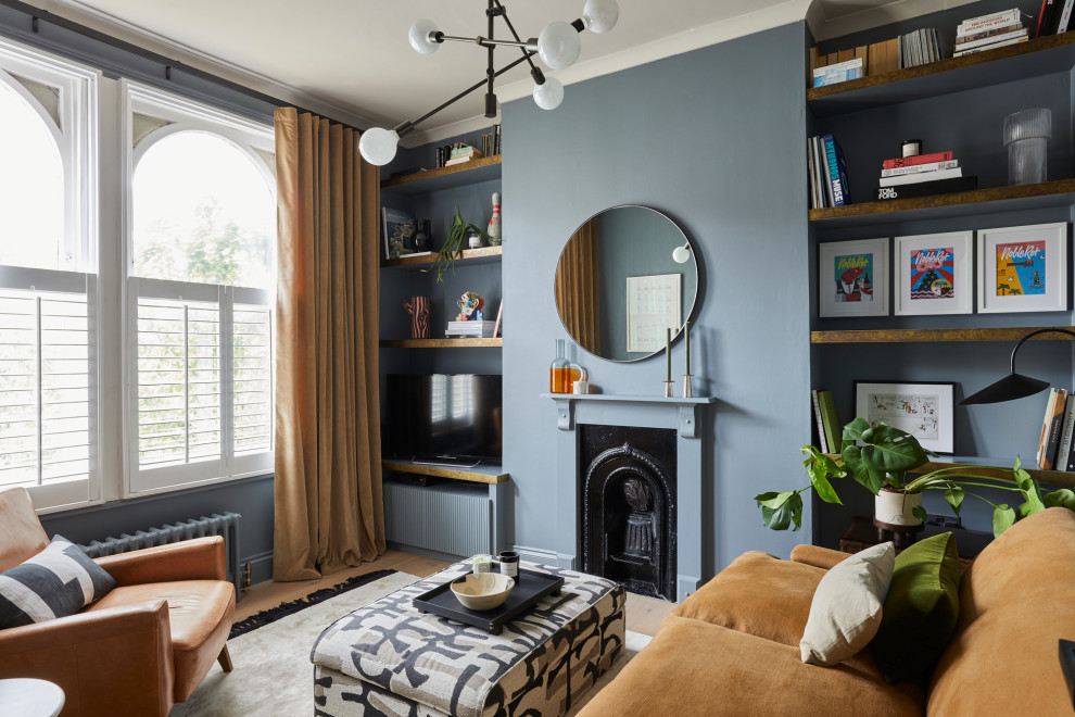 This is an example of a small transitional enclosed living room in London with blue walls, light hardwood floors, a standard fireplace, a wood fireplace surround, a built-in media wall, beige floor and coffered.