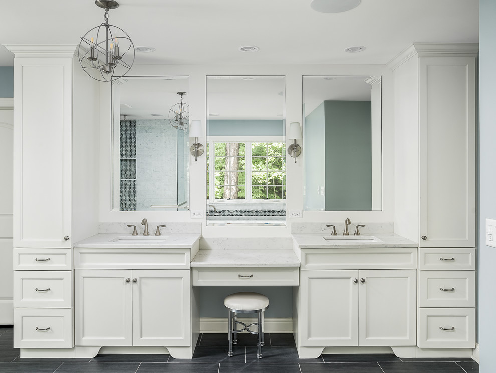 Photo of a large transitional master bathroom in Chicago with recessed-panel cabinets, white cabinets, a freestanding tub, an alcove shower, blue walls, an undermount sink and a hinged shower door.