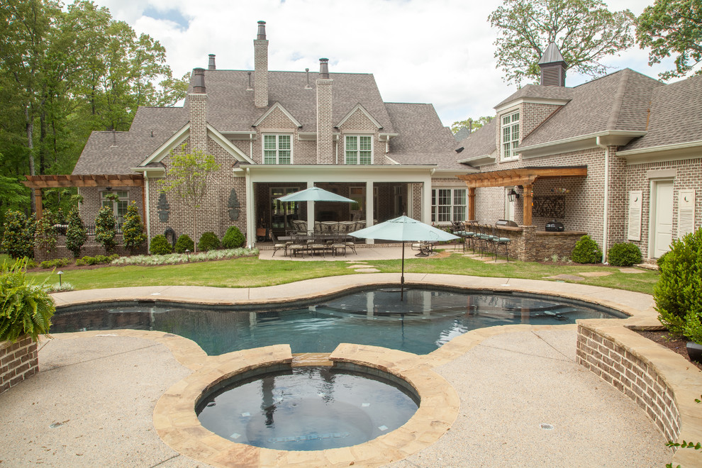 Design ideas for a large traditional backyard custom-shaped pool in Nashville with a hot tub and concrete slab.