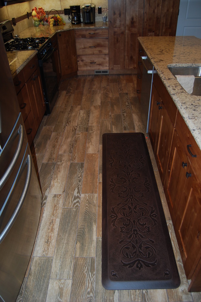 Inspiration for a mid-sized rustic l-shaped porcelain tile and brown floor eat-in kitchen remodel with an undermount sink, medium tone wood cabinets, beige backsplash, porcelain backsplash, an island, shaker cabinets, quartz countertops and stainless steel appliances