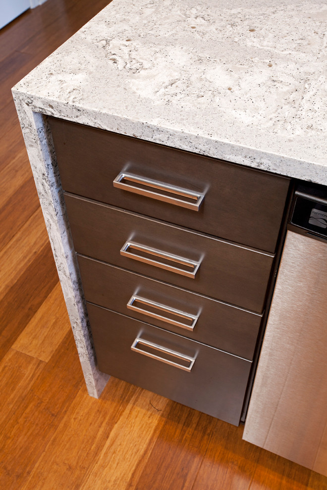 Eat-in kitchen - mid-sized transitional u-shaped medium tone wood floor eat-in kitchen idea in Minneapolis with an undermount sink, flat-panel cabinets, dark wood cabinets, gray backsplash, glass tile backsplash, stainless steel appliances and a peninsula