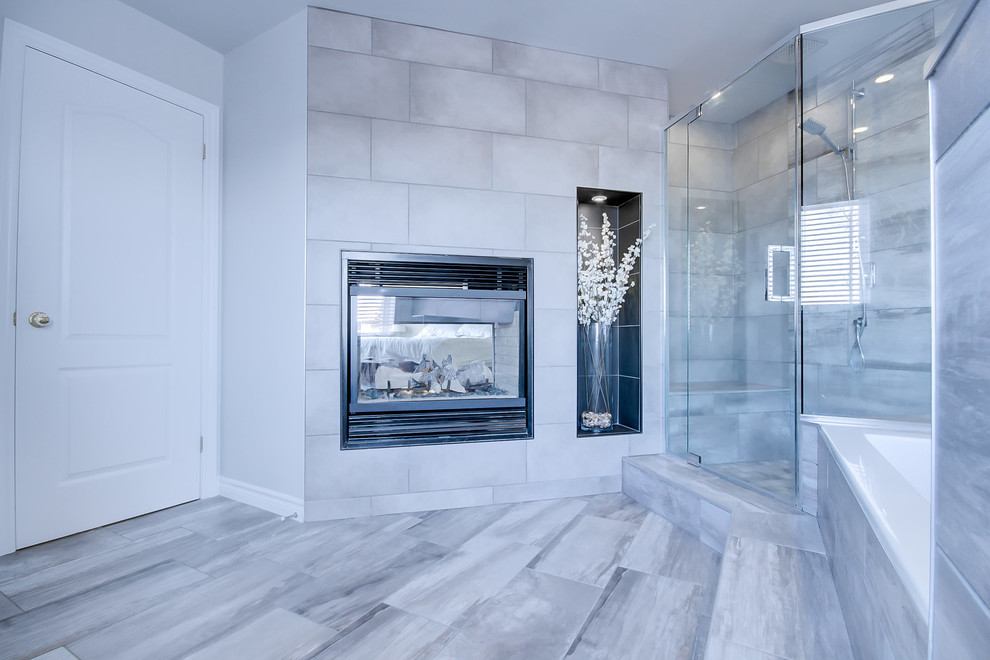 Large contemporary master bathroom in Ottawa with recessed-panel cabinets, white cabinets, a drop-in tub, a double shower, a two-piece toilet, gray tile, porcelain tile, grey walls, porcelain floors, an undermount sink, engineered quartz benchtops, grey floor, a hinged shower door and black benchtops.