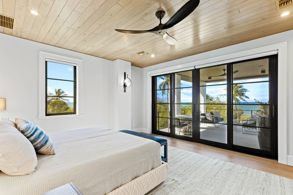 Immagine di una camera da letto design di medie dimensioni con pareti bianche, parquet chiaro e soffitto in legno