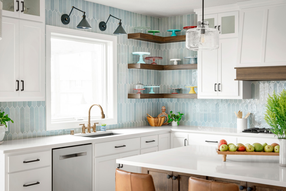 Küche mit weißen Schränken, Quarzwerkstein-Arbeitsplatte, Küchenrückwand in Blau, Rückwand aus Keramikfliesen, Küchengeräten aus Edelstahl und weißer Arbeitsplatte in Minneapolis