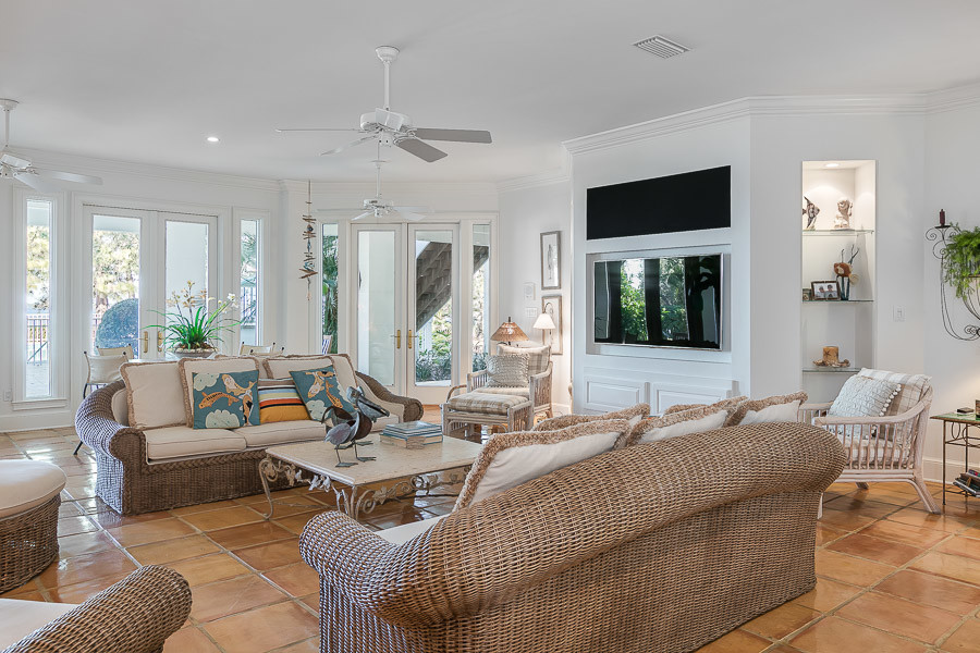 Mid-sized traditional open concept family room in Miami with white walls, terra-cotta floors and a built-in media wall.