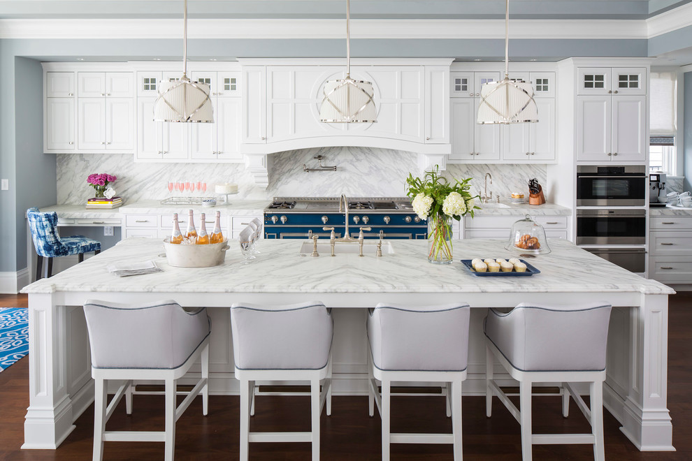 Example of a large transitional l-shaped medium tone wood floor and brown floor open concept kitchen design in Minneapolis with an undermount sink, recessed-panel cabinets, white cabinets, marble countertops, white backsplash, marble backsplash, stainless steel appliances and an island