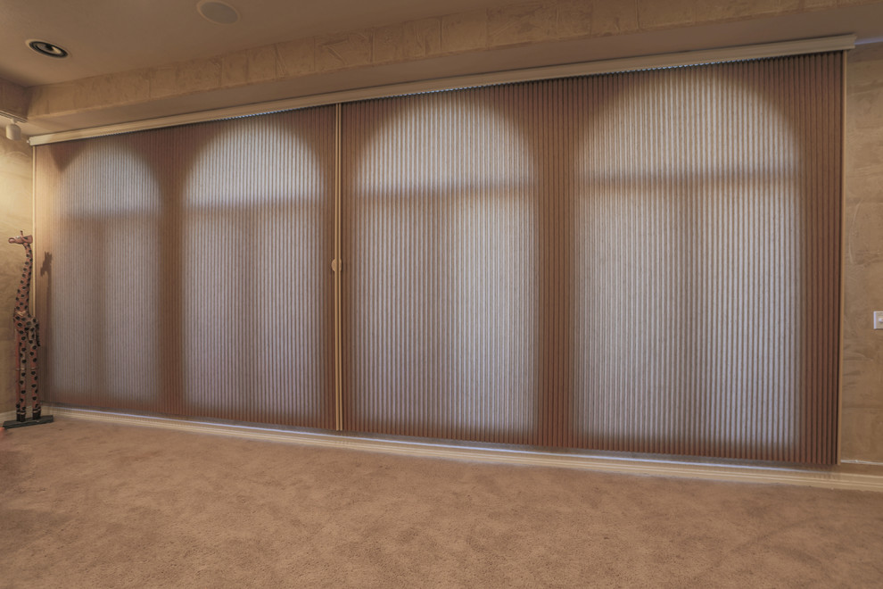 Example of a large classic enclosed carpeted home design design in Omaha with beige walls, a two-sided fireplace and a media wall