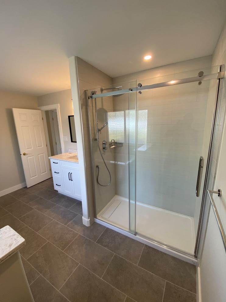 Inspiration for a mid-sized transitional master gray floor and single-sink sliding shower door remodel with shaker cabinets, white cabinets, a one-piece toilet, gray walls, an undermount sink and a built-in vanity