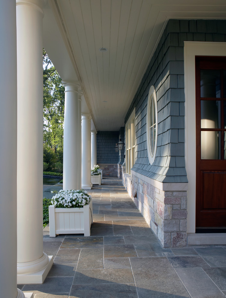 Mid-sized classic stone porch idea in Detroit with a roof extension