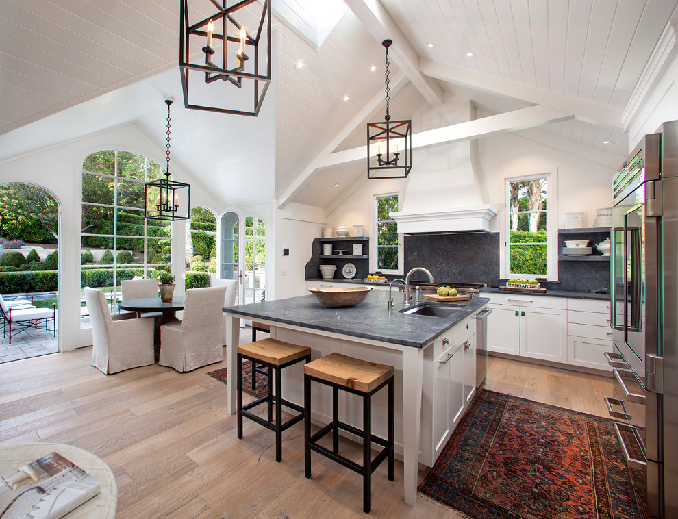 Inspiration for an expansive country open plan kitchen in Santa Barbara with a drop-in sink, shaker cabinets, white cabinets, light hardwood floors and with island.