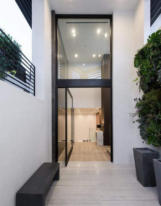 Mittelgroße Moderne Haustür mit weißer Wandfarbe, Kalkstein, Drehtür, schwarzer Haustür und grauem Boden in Los Angeles