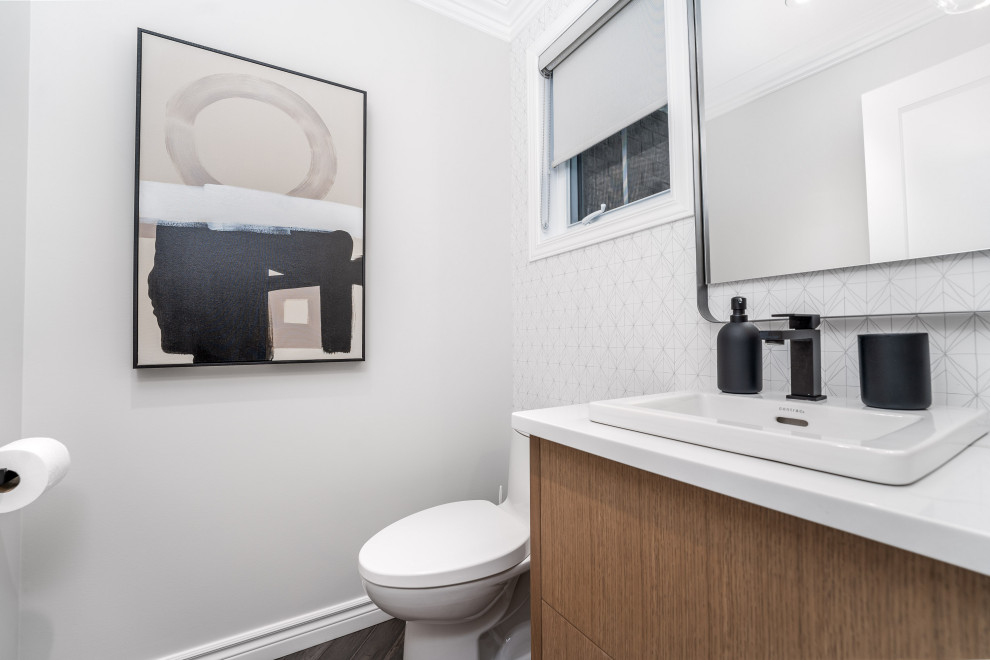 Photo of a small contemporary cloakroom in Toronto with flat-panel cabinets, light wood cabinets, a one-piece toilet, porcelain flooring, a built-in sink, engineered stone worktops, grey floors, white worktops, a floating vanity unit and wallpapered walls.