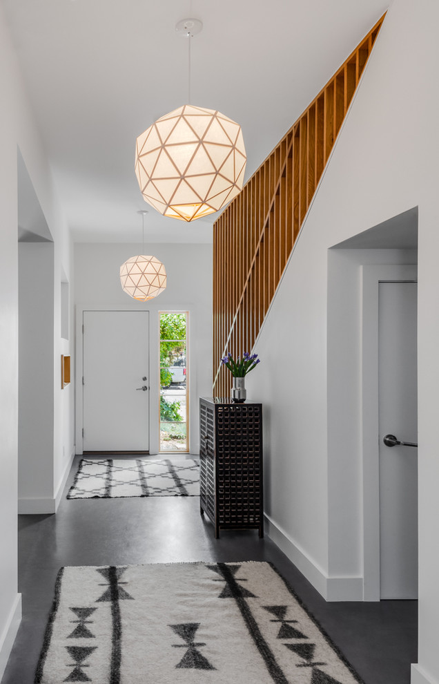 Design ideas for a contemporary entry hall in Denver with white walls, concrete floors and grey floor.