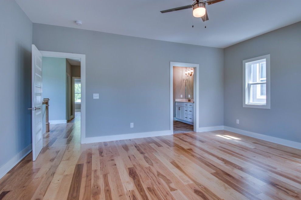 Inspiration for a large traditional master bedroom in Nashville with beige walls and light hardwood floors.