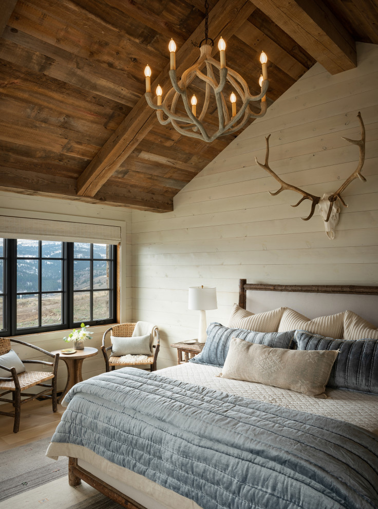 Rustic master bedroom in Other with white walls and a vaulted ceiling.