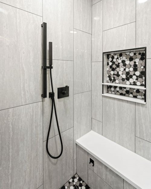 Klassisk inredning av ett turkos turkost badrum med dusch, med luckor med infälld panel, grå skåp, grå kakel, vinylgolv, bänkskiva i kvartsit och grått golv