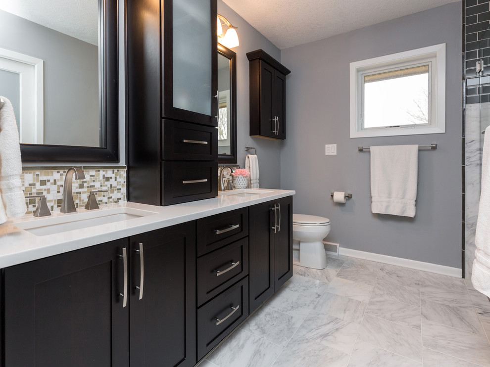 Inspiration for a mid-sized transitional master gray tile and mosaic tile marble floor walk-in shower remodel with an undermount sink, recessed-panel cabinets, dark wood cabinets, quartzite countertops, a one-piece toilet and gray walls