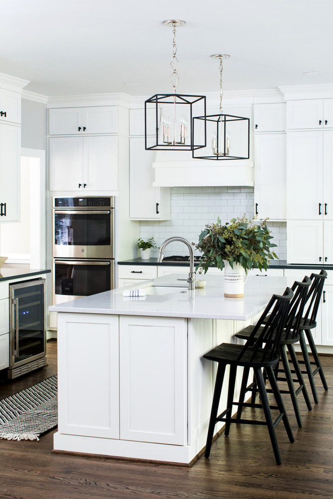 Inspiration for a transitional eat-in kitchen in Raleigh with shaker cabinets, white cabinets, quartz benchtops, white splashback, stainless steel appliances, dark hardwood floors, with island and brown floor.
