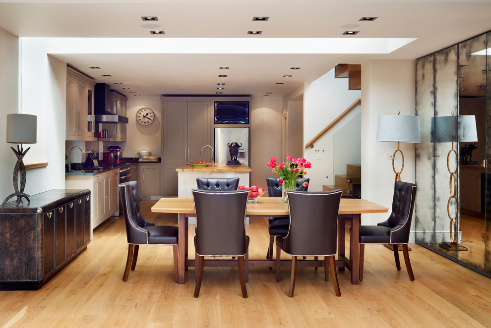Photo of a large contemporary open plan dining in London with white walls and light hardwood floors.