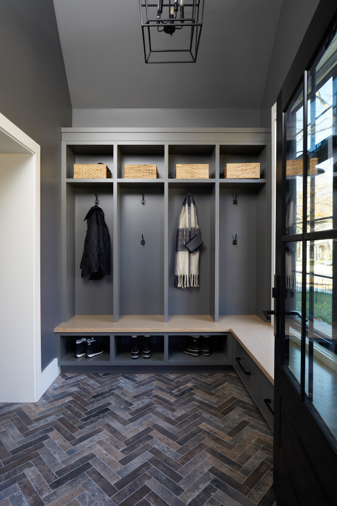 На фото: тамбур среднего размера в стиле неоклассика (современная классика) с серыми стенами, полом из сланца, одностворчатой входной дверью, черной входной дверью, разноцветным полом и сводчатым потолком с
