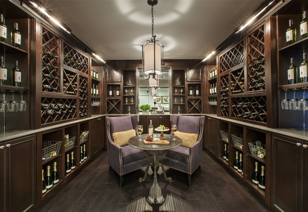 Photo of a transitional wine cellar in New York with dark hardwood floors, display racks and brown floor.