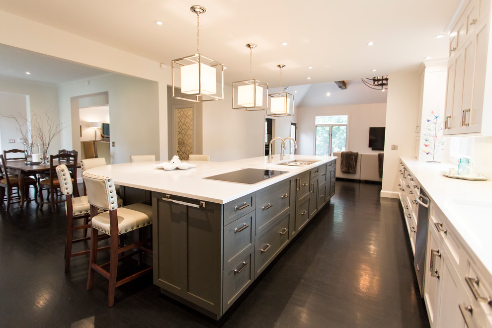 Kitchen - large transitional l-shaped dark wood floor and brown floor kitchen idea with an undermount sink, shaker cabinets, white cabinets, quartz countertops, white backsplash, stainless steel appliances, an island and white countertops