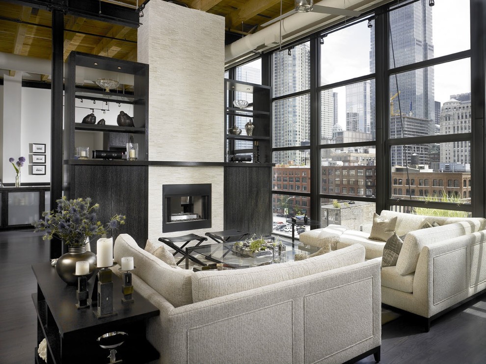 This is an example of an industrial open concept living room in Chicago with a two-sided fireplace.