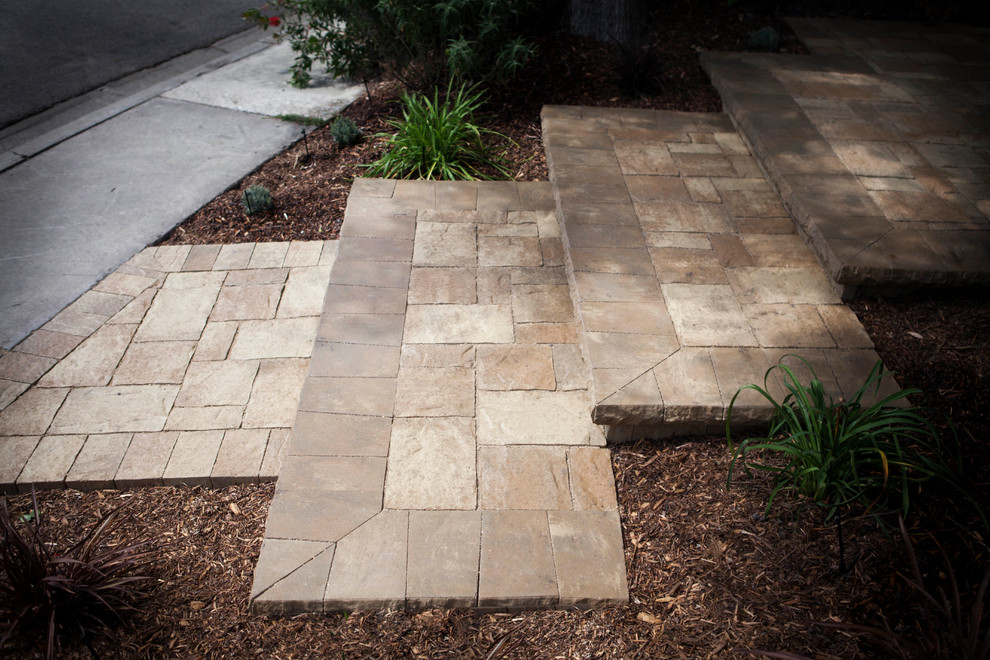 Mid-sized mediterranean front yard patio in Orange County with natural stone pavers.