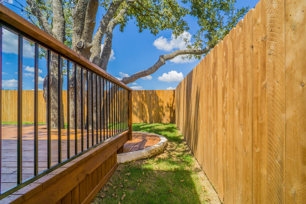 Photo of a mid-sized country backyard deck in Austin with a roof extension.