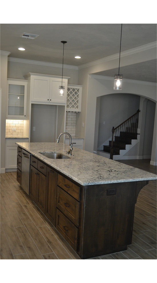 Transitional porcelain tile kitchen photo with a single-bowl sink, shaker cabinets, dark wood cabinets, granite countertops, white backsplash, subway tile backsplash, stainless steel appliances and an island