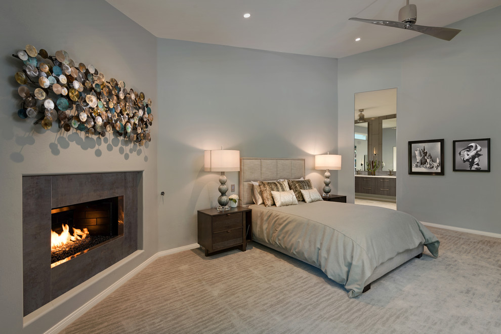 Inspiration for a large transitional master bedroom in Phoenix with grey walls, ceramic floors, a tile fireplace surround and a standard fireplace.