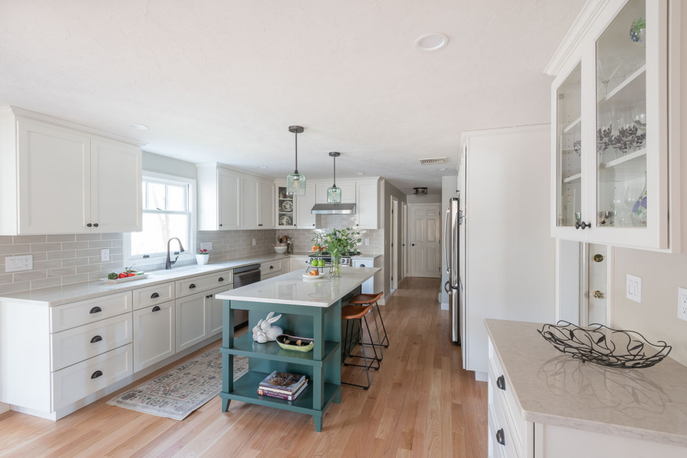 Large transitional galley light wood floor and brown floor eat-in kitchen photo in Boston with an undermount sink, shaker cabinets, white cabinets, quartz countertops, beige backsplash, ceramic backsplash, stainless steel appliances, an island and white countertops