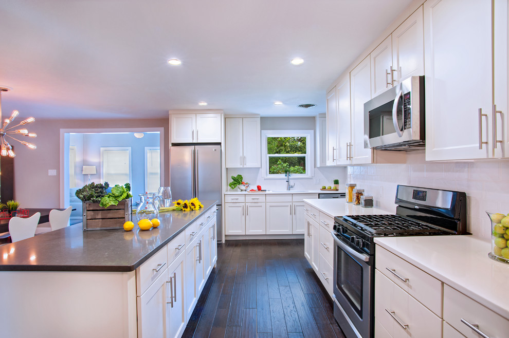 Inspiration for a mid-sized modern galley eat-in kitchen in Austin with a drop-in sink, flat-panel cabinets, white cabinets, quartz benchtops, white splashback, ceramic splashback, stainless steel appliances, dark hardwood floors and with island.