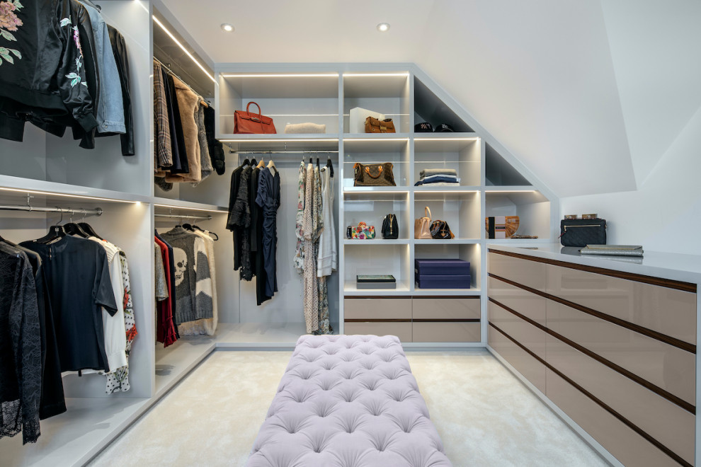 Inspiration for a mid-sized contemporary women's walk-in wardrobe in Essex with flat-panel cabinets, beige cabinets, carpet and white floor.