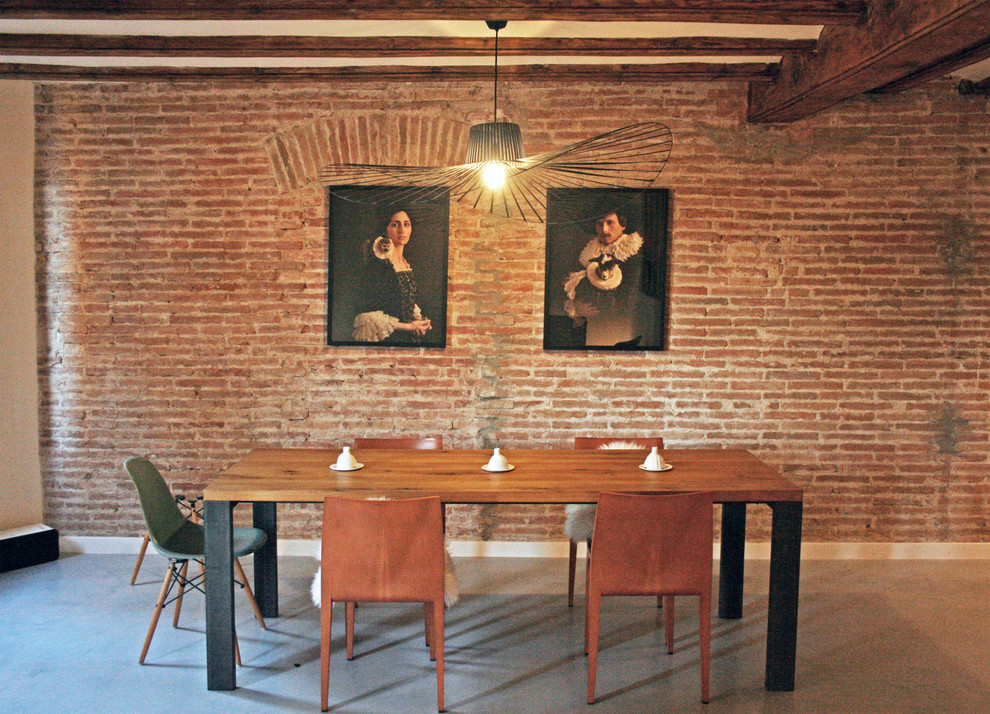 Mid-sized industrial open plan dining in Barcelona with red walls, concrete floors, no fireplace and grey floor.