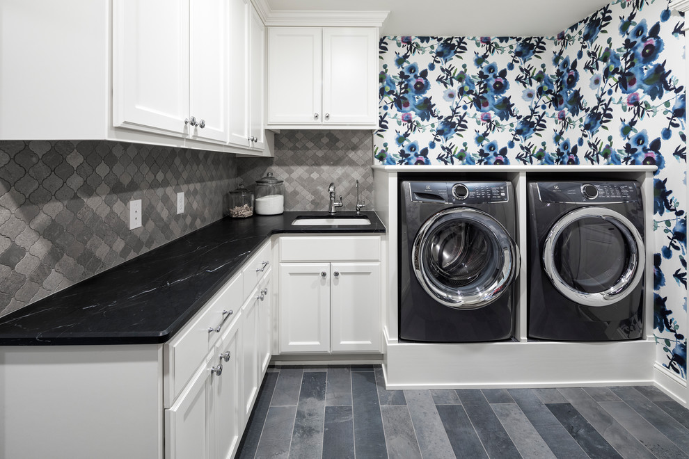 Design ideas for a large l-shaped dedicated laundry room in Minneapolis with an undermount sink, flat-panel cabinets, white cabinets, soapstone benchtops, multi-coloured walls, ceramic floors, a side-by-side washer and dryer, grey floor and black benchtop.