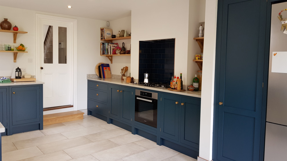 ロンドンにある高級な中くらいなトランジショナルスタイルのおしゃれなキッチン (アンダーカウンターシンク、シェーカースタイル扉のキャビネット、青いキャビネット、珪岩カウンター、青いキッチンパネル、サブウェイタイルのキッチンパネル、シルバーの調理設備、磁器タイルの床、グレーの床、グレーのキッチンカウンター) の写真