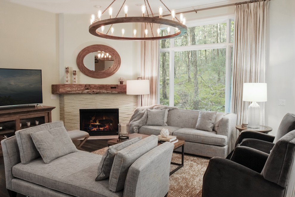 This is an example of a mid-sized transitional open concept living room in Grand Rapids with grey walls, dark hardwood floors, a corner fireplace, a stone fireplace surround and a freestanding tv.