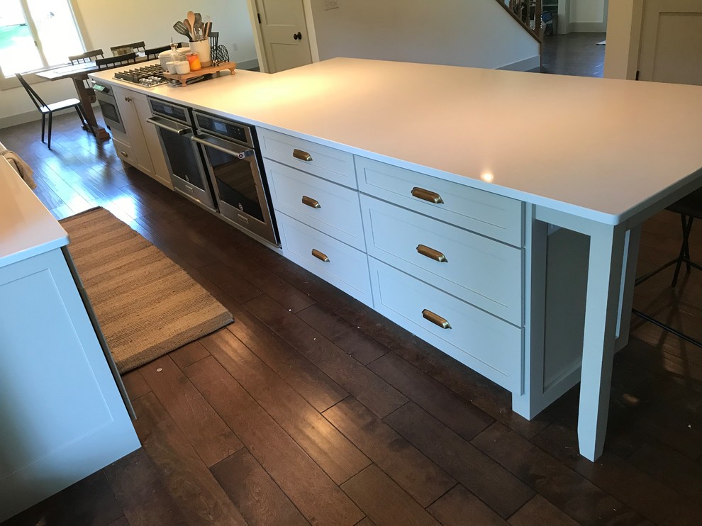 Eat-in kitchen - large transitional galley dark wood floor and brown floor eat-in kitchen idea in Chicago with a farmhouse sink, shaker cabinets, beige cabinets, quartz countertops, white backsplash, subway tile backsplash, stainless steel appliances, an island and white countertops