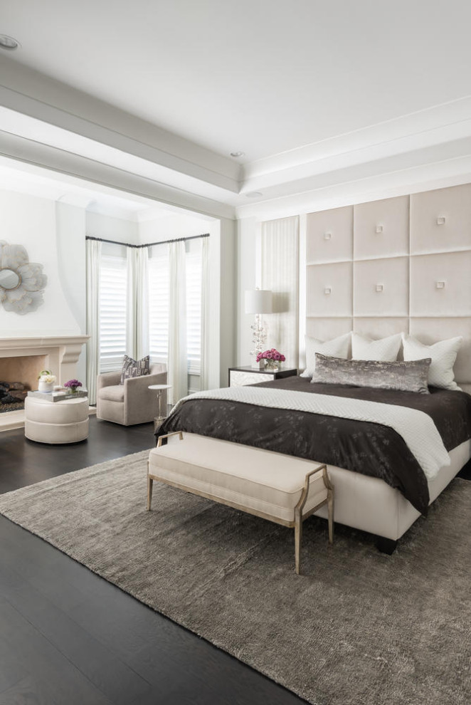 Design ideas for a large mediterranean master bedroom in Dallas with white walls, dark hardwood floors, a standard fireplace, a plaster fireplace surround and black floor.