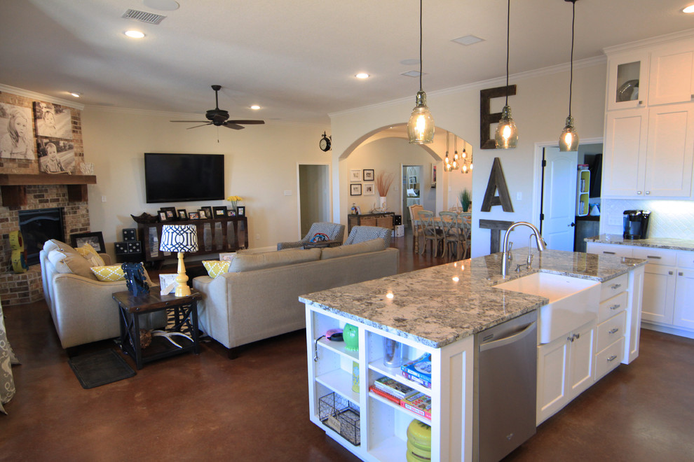 Inspiration for a large transitional l-shaped eat-in kitchen in Austin with concrete floors, a farmhouse sink, shaker cabinets, white cabinets, granite benchtops, white splashback, mosaic tile splashback, stainless steel appliances and with island.